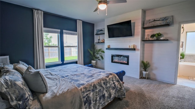 21386 Owl Rd, New Caney, TX 77357 - carpeted bedroom featuring a glass covered fireplace, a ceiling fan, and ensuite bath