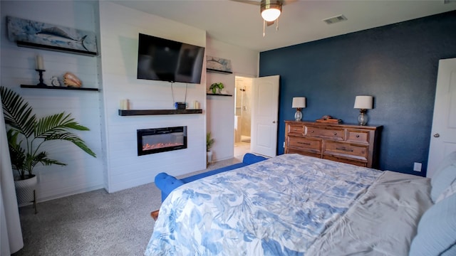 21386 Owl Rd, New Caney, TX 77357 - carpeted bedroom with a glass covered fireplace and ceiling fan