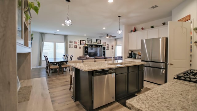 21386 Owl Rd, New Caney, TX 77357 - kitchen with appliances with stainless steel finishes, an island with sink, light stone countertops, recessed lighting, and a sink