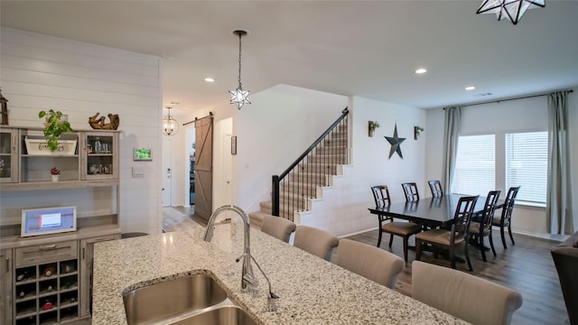 21386 Owl Rd, New Caney, TX 77357 - kitchen with a sink, a barn door, recessed lighting, wood finished floors, and decorative light fixtures
