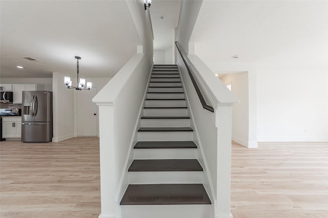 12034 Audubon Hill Ct, Houston, TX 77038 - stairway featuring wood finished floors, a chandelier, baseboards, and recessed lighting