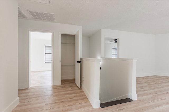 12034 Audubon Hill Ct, Houston, TX 77038 - hallway with light wood-style flooring, an upstairs landing, and baseboards