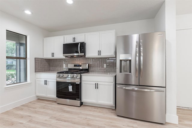 12034 Audubon Hill Ct, Houston, TX 77038 - kitchen featuring stainless steel appliances, light countertops, white cabinets, tasteful backsplash, and light wood-style floors