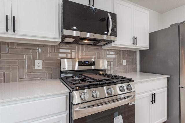 12034 Audubon Hill Ct, Houston, TX 77038 - kitchen with appliances with stainless steel finishes, tasteful backsplash, and white cabinetry