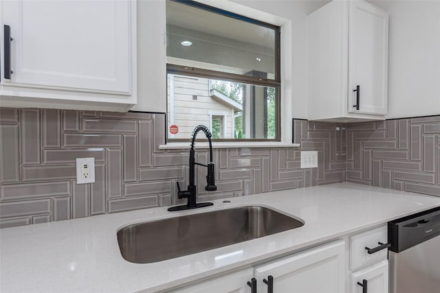 12034 Audubon Hill Ct, Houston, TX 77038 - kitchen featuring stainless steel dishwasher, a sink, decorative backsplash, and white cabinetry