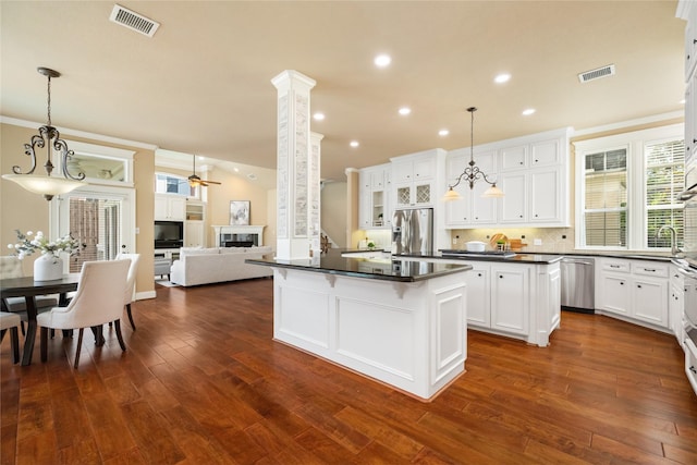 5811 Cimmaron Creek Ct, Spring, TX 77379 - kitchen featuring a center island, stainless steel appliances, dark countertops, ceiling fan, and white cabinetry