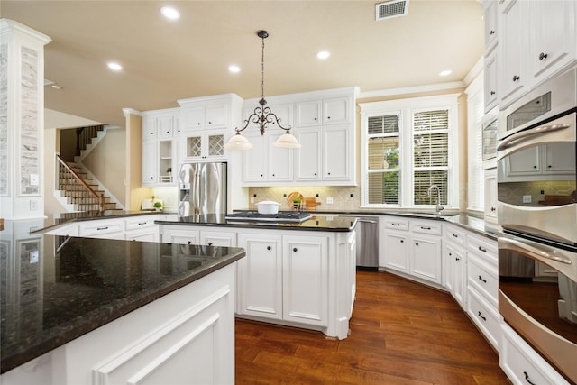 5811 Cimmaron Creek Ct, Spring, TX 77379 - kitchen with stainless steel appliances, recessed lighting, backsplash, white cabinetry, and dark wood-style flooring