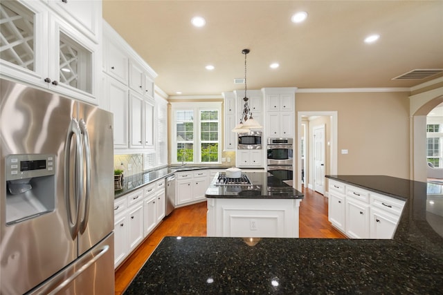 5811 Cimmaron Creek Ct, Spring, TX 77379 - kitchen featuring stainless steel appliances, crown molding, decorative backsplash, wood finished floors, and a center island