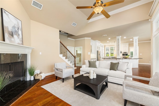 5811 Cimmaron Creek Ct, Spring, TX 77379 - living room featuring wood finished floors, stairway, baseboards, vaulted ceiling, and ornamental molding