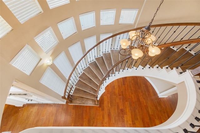 5811 Cimmaron Creek Ct, Spring, TX 77379 - stairway featuring a towering ceiling, a chandelier, and wood finished floors