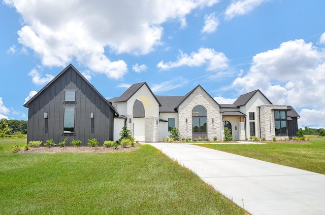 20218 Tealpointe Ridge Ln, Tomball, TX 77377 - view of front of house featuring a front yard, board and batten siding, stone siding, and driveway