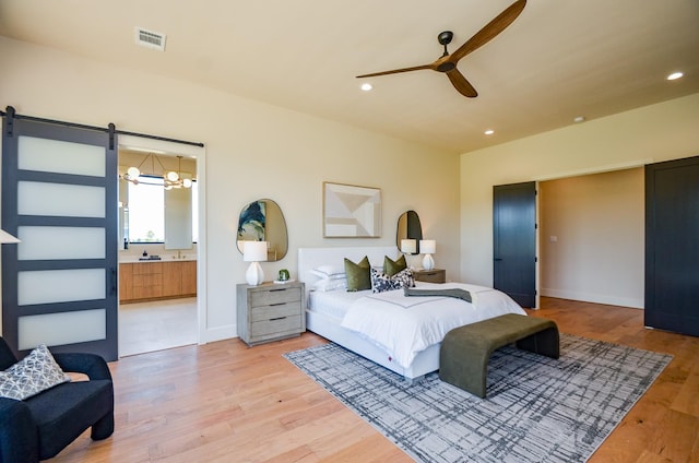 20218 Tealpointe Ridge Ln, Tomball, TX 77377 - bedroom with light wood finished floors, recessed lighting, a chandelier, a barn door, and ensuite bathroom