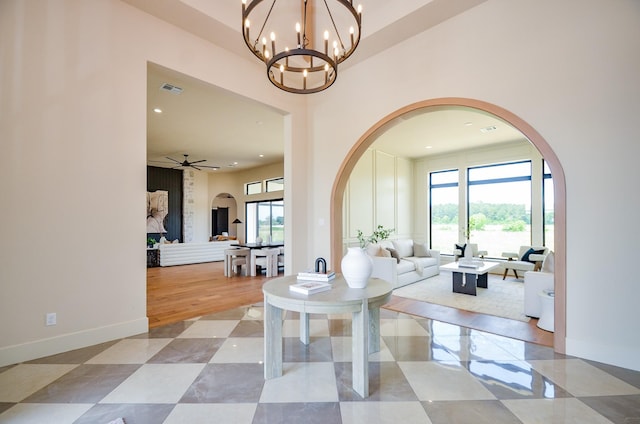 20218 Tealpointe Ridge Ln, Tomball, TX 77377 - living room featuring arched walkways, a high ceiling, a ceiling fan, a chandelier, and recessed lighting