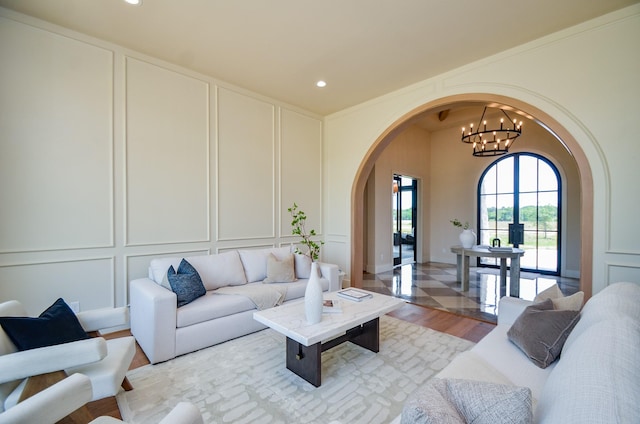 20218 Tealpointe Ridge Ln, Tomball, TX 77377 - living room featuring a decorative wall, arched walkways, recessed lighting, a chandelier, and light wood-style floors