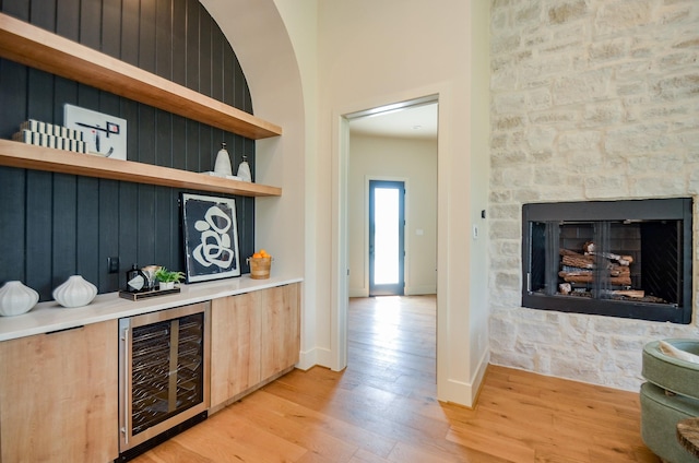 20218 Tealpointe Ridge Ln, Tomball, TX 77377 - indoor dry bar featuring beverage cooler, light wood finished floors, and a fireplace