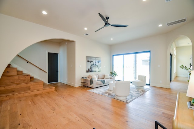 20218 Tealpointe Ridge Ln, Tomball, TX 77377 - living room with arched walkways, light wood-type flooring, a ceiling fan, recessed lighting, and stairway