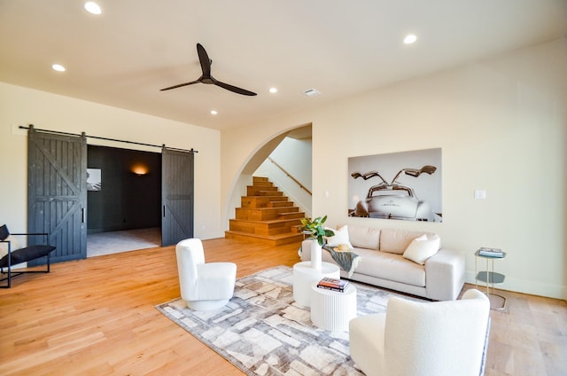 20218 Tealpointe Ridge Ln, Tomball, TX 77377 - living room with a barn door, wood finished floors, recessed lighting, ceiling fan, and stairway