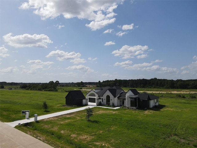 20218 Tealpointe Ridge Ln, Tomball, TX 77377 - view of front facade featuring a front lawn, a garage, concrete driveway, and a view of countryside