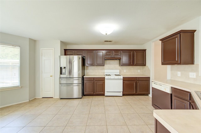 19814 Lindenfield Pl, Katy, TX 77449 - kitchen with stainless steel fridge, white range with gas stovetop, dishwasher, under cabinet range hood, and light countertops