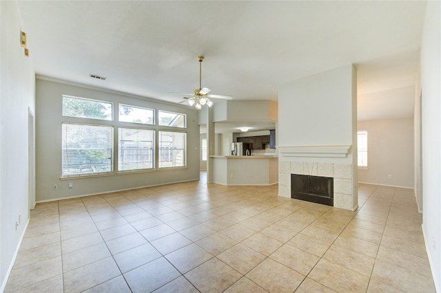 19814 Lindenfield Pl, Katy, TX 77449 - unfurnished living room featuring ceiling fan, light tile patterned flooring, a tiled fireplace, and baseboards