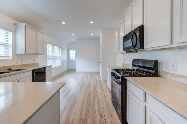 22619 Malvicino Dr, New Caney, TX 77357 - kitchen featuring black appliances, light wood finished floors, a sink, recessed lighting, and light countertops