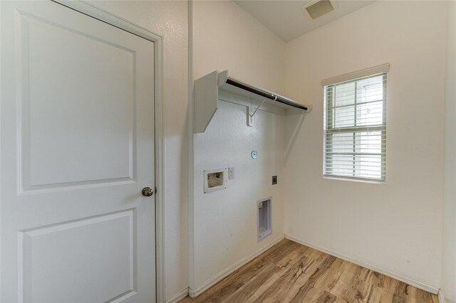 22619 Malvicino Dr, New Caney, TX 77357 - laundry area featuring hookup for a gas dryer, electric dryer hookup, washer hookup, light wood-type flooring, and baseboards