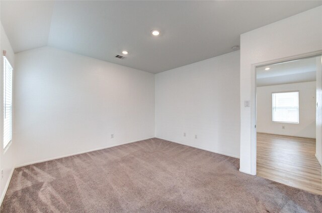 22619 Malvicino Dr, New Caney, TX 77357 - unfurnished room featuring light carpet, vaulted ceiling, baseboards, and recessed lighting