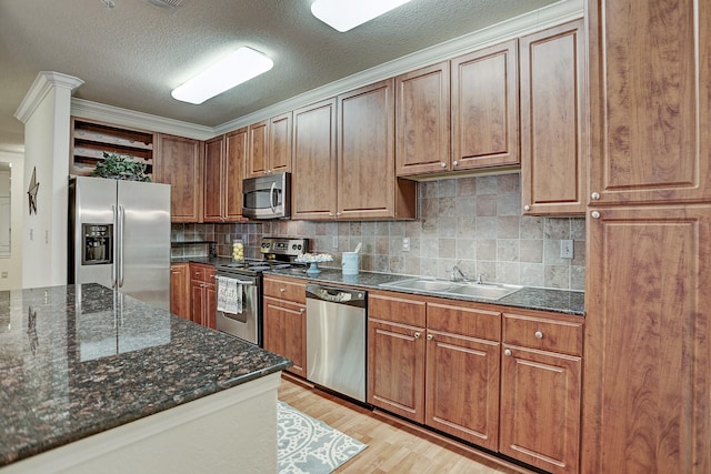1711 Old Spanish Trl Unit 438, Houston, TX 77054 - kitchen with stainless steel appliances, open shelves, a sink, light wood finished floors, and backsplash