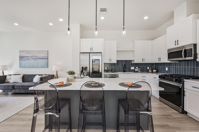 4917 Randon Rd, Houston, TX 77092 - kitchen with appliances with stainless steel finishes, a kitchen bar, decorative backsplash, a sink, and recessed lighting