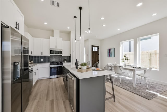 4917 Randon Rd, Houston, TX 77092 - kitchen featuring stainless steel appliances, light wood-style floors, an island with sink, backsplash, and recessed lighting