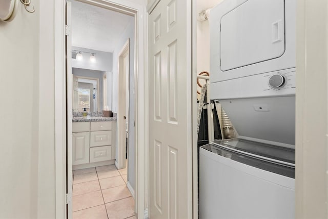 1881 Bering Dr Unit 25, Houston, TX 77057 - laundry room with estacked washer and dryer and light tile patterned flooring