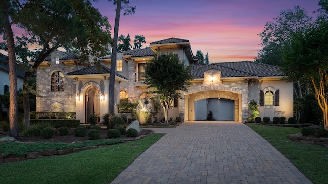 10 Maroon Creek Ct, Spring, TX 77389 - view of front of home featuring stone siding, a garage, a tiled roof, and decorative driveway