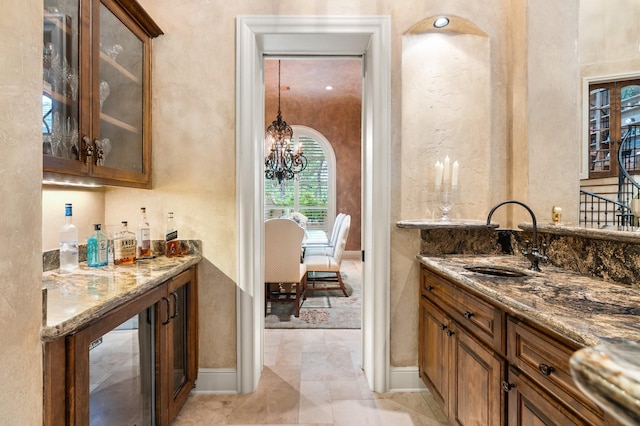10 Maroon Creek Ct, Spring, TX 77389 - indoor wet bar featuring a chandelier, baseboards, and a textured wall
