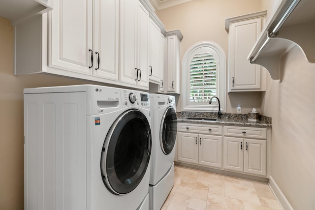 10 Maroon Creek Ct, Spring, TX 77389 - laundry area featuring washer and dryer, cabinet space, and light stone finish floors