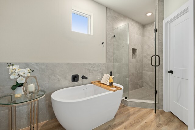 5809 Francis Oak Pl, Houston, TX 77091 - bathroom with tile walls, a freestanding bath, a stall shower, wood finished floors, and recessed lighting