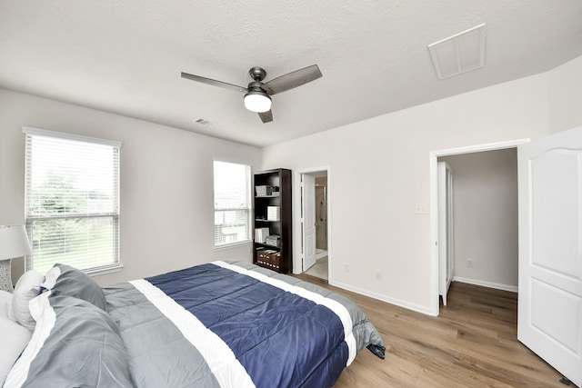 13003 Mills Creek Meadow Dr, Houston, TX 77070 - bedroom with light wood-type flooring, baseboards, and a ceiling fan
