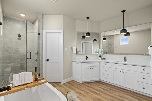 5811 Francis Oak Pl, Houston, TX 77091 - bathroom with a stall shower, double vanity, wood finished floors, and a bath