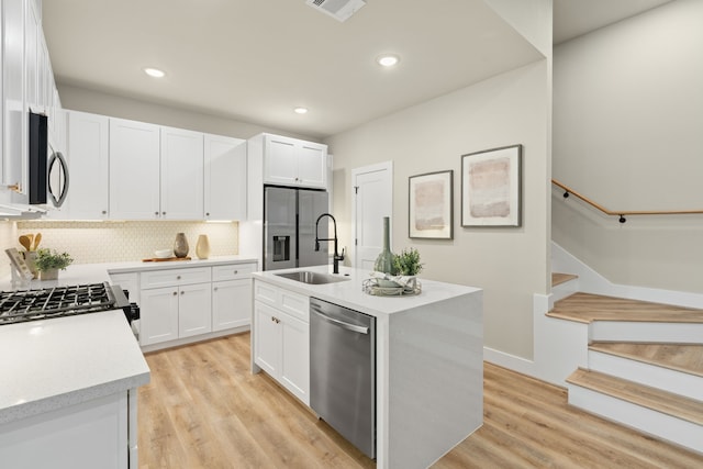 5811 Francis Oak Pl, Houston, TX 77091 - kitchen featuring stainless steel appliances, decorative backsplash, white cabinets, a kitchen island with sink, and recessed lighting