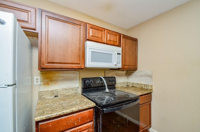 5914 Newquay St, Houston, TX 77085 - kitchen featuring white appliances, brown cabinetry, and light stone counters