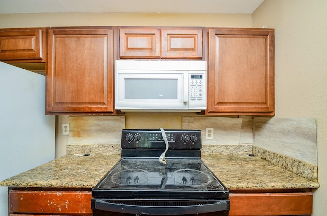 5914 Newquay St, Houston, TX 77085 - kitchen with white appliances, tasteful backsplash, light stone countertops, and brown cabinetry