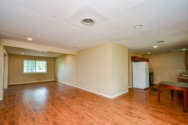 5914 Newquay St, Houston, TX 77085 - unfurnished living room featuring wood finished floors, baseboards, recessed lighting, and a sink