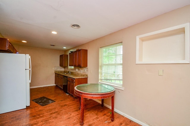 5914 Newquay St, Houston, TX 77085 - kitchen with freestanding refrigerator, a sink, dark wood-type flooring, brown cabinetry, and baseboards