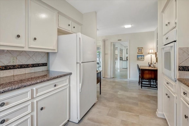 1705 E Texas Ave, Baytown, TX 77520 - kitchen with white appliances, tasteful backsplash, white cabinetry, and light stone counters