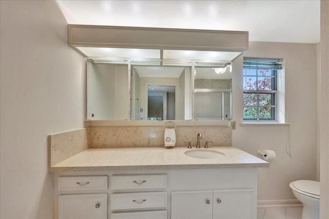 1705 E Texas Ave, Baytown, TX 77520 - full bath featuring vanity, toilet, a shower stall, tile patterned flooring, and baseboards