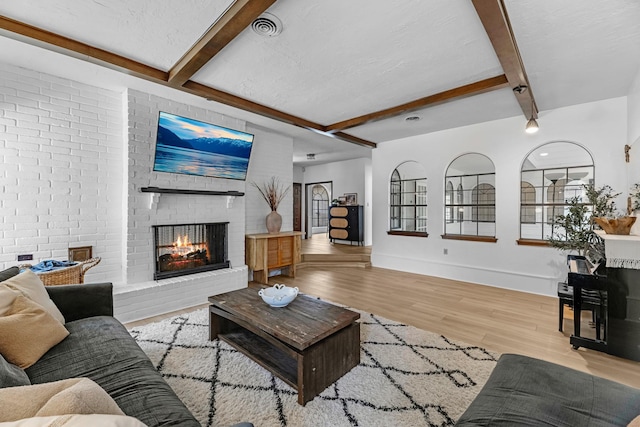 1915 Morton League Rd, Richmond, TX 77406 - living area with beam ceiling, wood finished floors, a fireplace, and baseboards