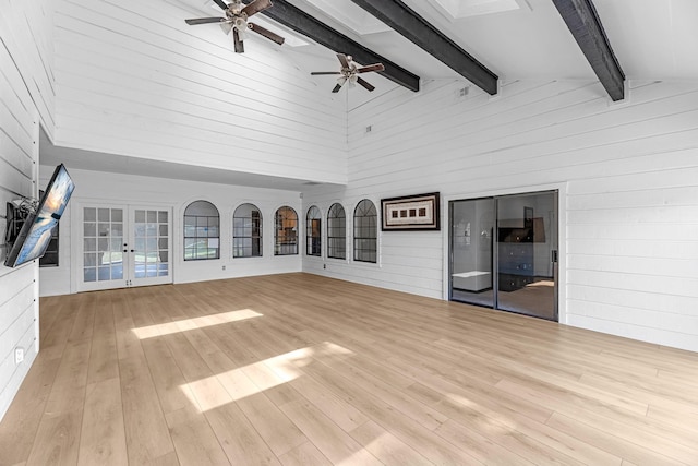 1915 Morton League Rd, Richmond, TX 77406 - unfurnished living room with high vaulted ceiling, wooden walls, a ceiling fan, wood finished floors, and beamed ceiling