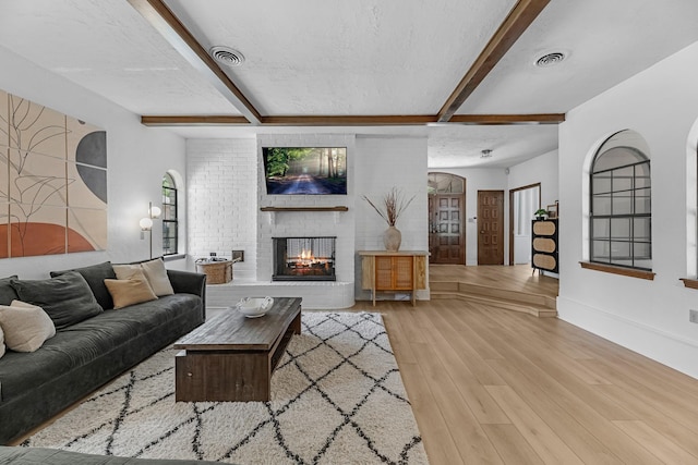 1915 Morton League Rd, Richmond, TX 77406 - living room featuring wood finished floors, beamed ceiling, a fireplace, and baseboards
