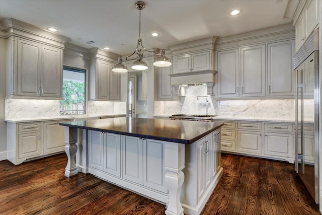 8304 Maple Ct, Bellaire, TX 77401 - kitchen with a kitchen island, dark wood-type flooring, tasteful backsplash, a sink, and recessed lighting
