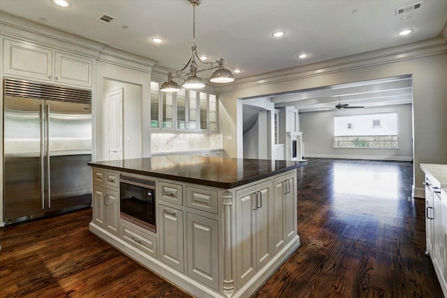 8304 Maple Ct, Bellaire, TX 77401 - kitchen featuring built in appliances, crown molding, a ceiling fan, dark wood finished floors, and a kitchen island