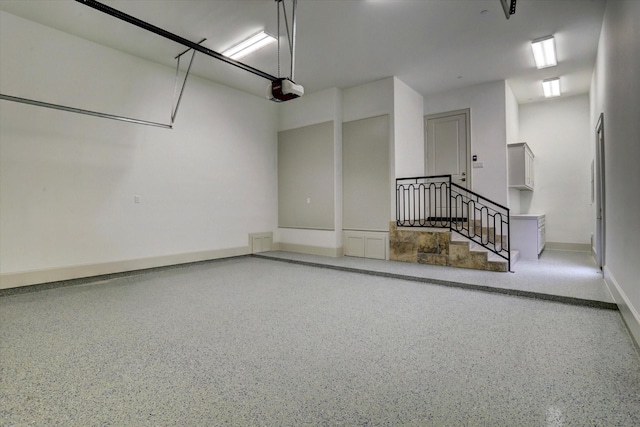 8304 Maple Ct, Bellaire, TX 77401 - garage featuring baseboards and a garage door opener